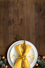 Festive Christmas table setting with yellow and gold colored decoration. Top view