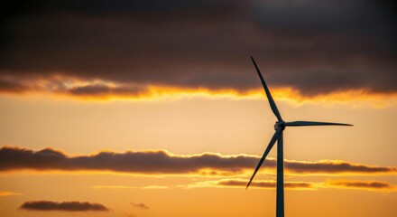Obraz premium Sunset silhouette of lone wind turbine dramatic sky