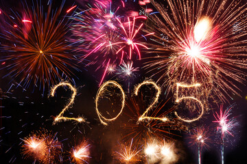 Happy new year 2025 text written with Sparkle bengal sparklers and firework illumination background,