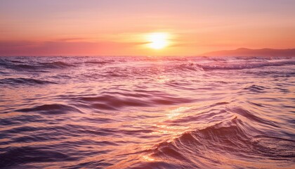 Obraz premium Sunset over the ocean with waves and mountains in the distance