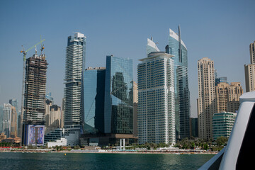Fototapeta premium View from the yacht to High-rise buildings with glass facade against blue sky. Business center. Beach view. View from below