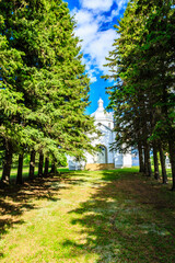 A church is surrounded by trees and the sky is blue