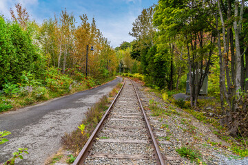 Obraz premium A view at the bottom of the Montmorency falls up a railway line beside the Saint Lawrence river near Quebec City, Canada in the fall