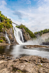 A long exposure view across the rocky shoreline at the bottom of the Montmorency falls near Quebec City, Canada in the fall