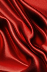Fototapeta premium Luxurious red silk fabric with smooth waves and glossy texture