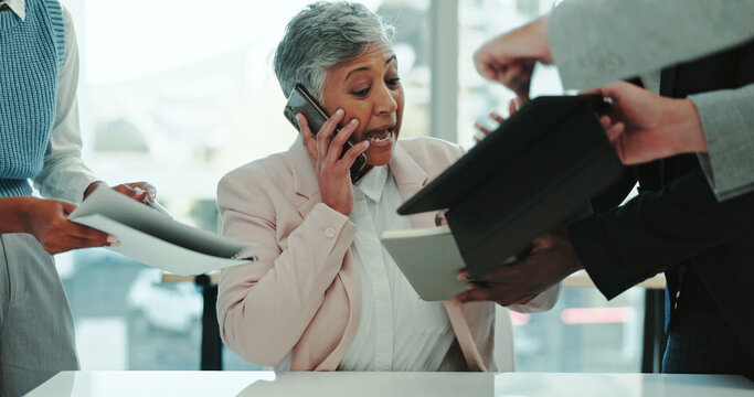 Multitasking, busy and businesswoman in office with people for juggling tasks with deadline. Technology, documents and mature female manager on phone call for deal negotiation with heavy workload. - Powered by Adobe