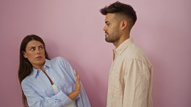 Woman rejecting advances from man against pink background showcasing reluctant emotions and interpersonal tension