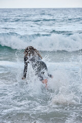 Side view of surfer carrying surfboard
