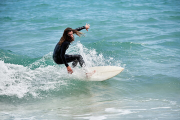 Surfboarder with long hair riding a wave