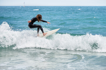 Long-haired bearded surfer on board riding waves