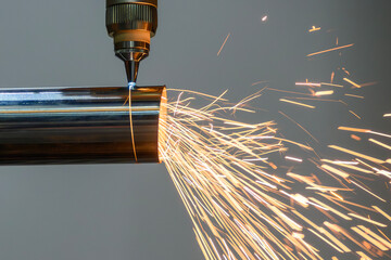 Close up scene the fiber laser cutting machine cut the stainless steel tube and sparkling light.