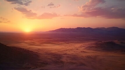 Obraz premium Stunning sunset over a vast desert landscape with mountains in the background. Colors blend beautifully at dusk.