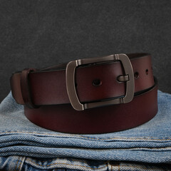 Men's Leather Belt and Blue Jeans on Stone Background