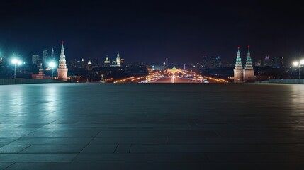 Night view of a cityscape featuring illuminated towers and a wide, empty plaza.