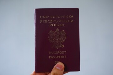 Polski paszport trzymany w dłoni. Paszport obowiązujący na terenie Unii Europejskiej.
