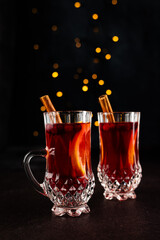 Two cups with hot spiced wine on dark background. Festive vibes. Place for text.