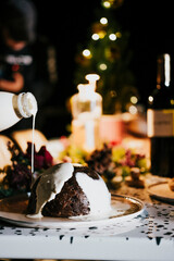 A bottle of milk is poured into a bowl of pudding. The bowl is on a table next to a bottle of wine