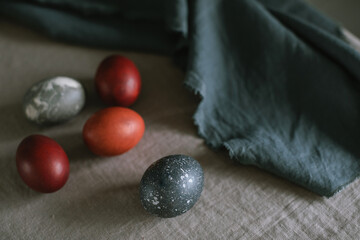 Close-up of five assorted painted Easter eggs on a linen tablecloth