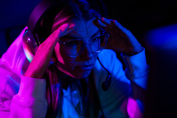 Photo of cute charming blonde girl panic stressed lose play gamer computer purple blue neon light indoors late night