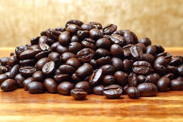 Pile of roasted coffee beans on wooden surface