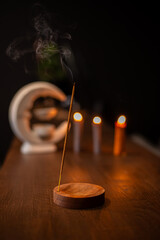 incense stick smokes on a wooden stand on a dark background. Aromatherapy, Smoke while burning incense. smoke for prayers and meditation. prayer to buddha. incense for relaxation and yoga