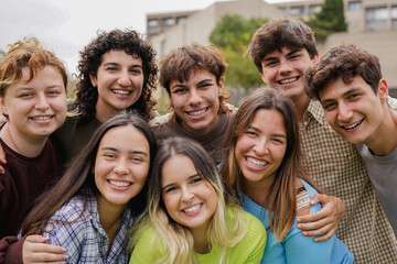 Group of adult students having fun together outside of university school building - Diverse teenager people posing in front of camera outdoor