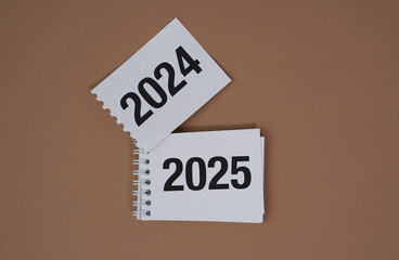 Two pieces of paper with the numbers 2024 and 2025 on them, Mocha Mousse