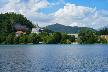 Fototapeta premium BLED, SLOVENIA -22 JUNE 2024- Landscape view of Lake Bled in summer. Bled is a lake in the Julian Alps of the Upper Carniolan region of northwestern Slovenia with a castle on an island.