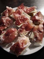 Delicious appetizers with cured ham and cheese resting on toasted bread slices November