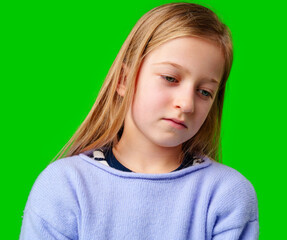 A young child in a light purple sweater gazes against a green background while deep in thought