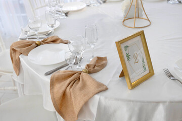 white plate with spoon and knife on tablecloth at banquet with decor	
