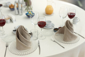 white plate with spoon and knife on tablecloth at banquet with decor	
