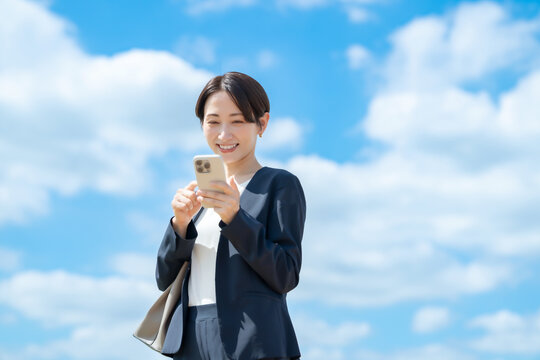 ビジネス女性・スマホ・青空