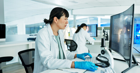 Scientist, woman and reading by computer in lab with medical research, review or solution with...