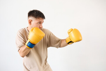 Athletic young boxing trainer puts on gloves and practices a punch