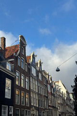 Amsterdam old houses against blue sky.