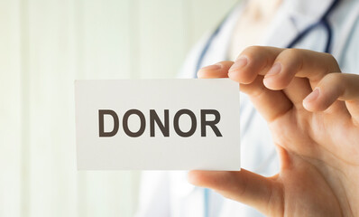 Doctor holding a card with text DONOR, medical concept