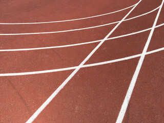 Fototapeta premium Red treadmill with the lines at the stadium. Treadmill lane on sport field. Running track on the stadium. Red treadmill in sport field. Running track