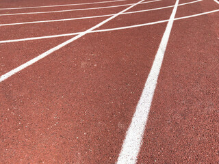 Red treadmill with the lines at the stadium. Treadmill lane on sport field. Running track on the stadium. Red treadmill in sport field. Running track