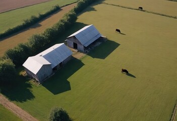An expansive aerial view showcases two barns situated in a lush grassy field