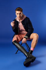 Young man with a prosthetic leg is seated confidently, showcasing his style and individuality.
