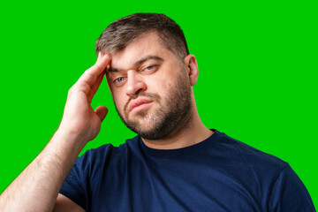 A man with closed eyes holds his head in a thoughtful pose against a bright green backdrop