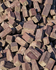 Close-up of a pile of old Dutch red rectangular street bricks that can be reused. 