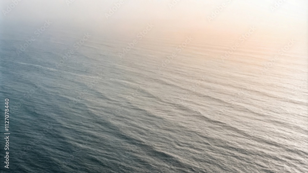 Poster a serene and misty seascape with subtle waves rippling across the vast expanse of the ocean, bathed 