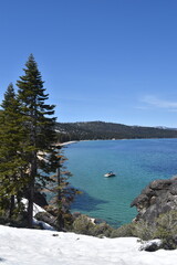 The turquoise azure blue Lake Tahoe and the surrounding mountains and forest 