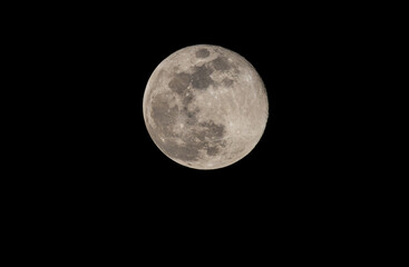Close up of full moon on the dark night seen with the lens super