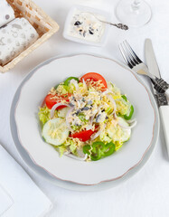 Mixed salad with dressing, served on an elegant table...