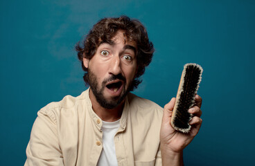 young adult bearded man with a boots brush