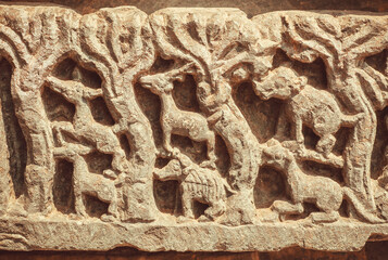 Wild animals and trees of forest on stone relief, abandoned Indian temple artwork