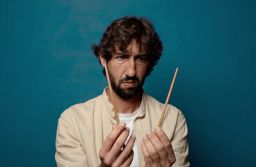 young adult bearded man with chopsticks